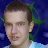 A selfie of my face in front of a green and blue AiChaos logo.
